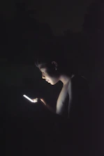 Close-up of a business professional reviewing a glowing contact database on a dark screen.