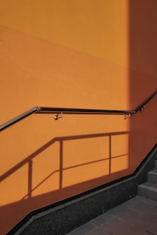 a man walking down a flight of stairs next to a yellow wall