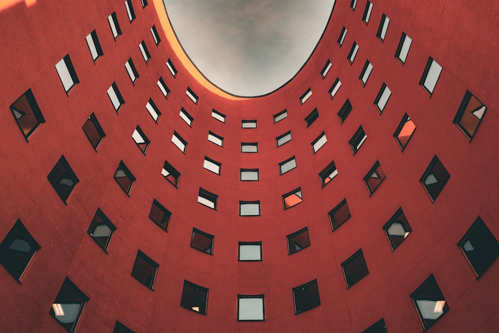 a red building with lots of windows and a sky background