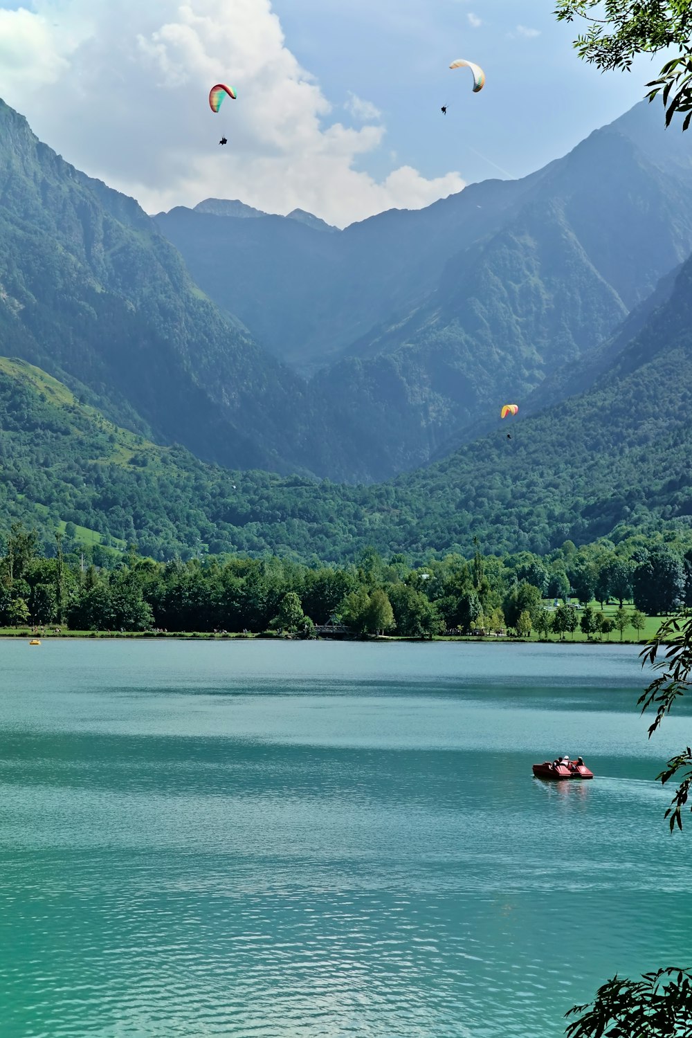 a group of people para sailing on a lake