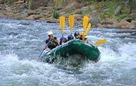 a group of people riding on the back of a raft down a river