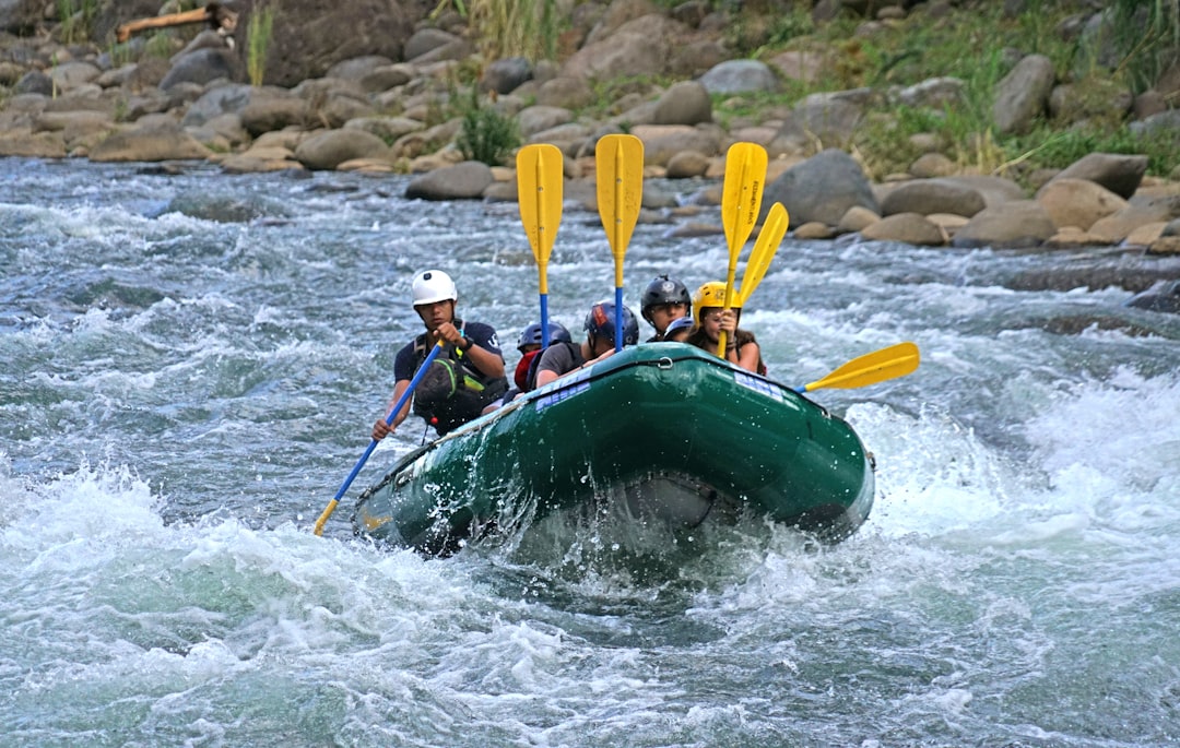 a group of people riding on the back of a raft down a river,