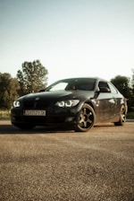 A sleek sports car gleaming under natural sunlight on an open road.