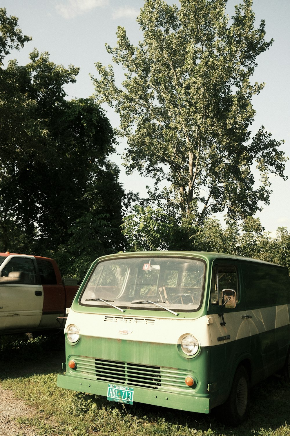 a green van parked next to a white truck