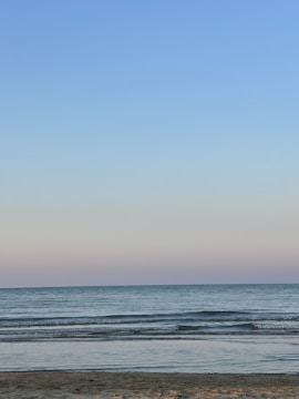 A serene beach scene with gentle waves and a pastel sky.