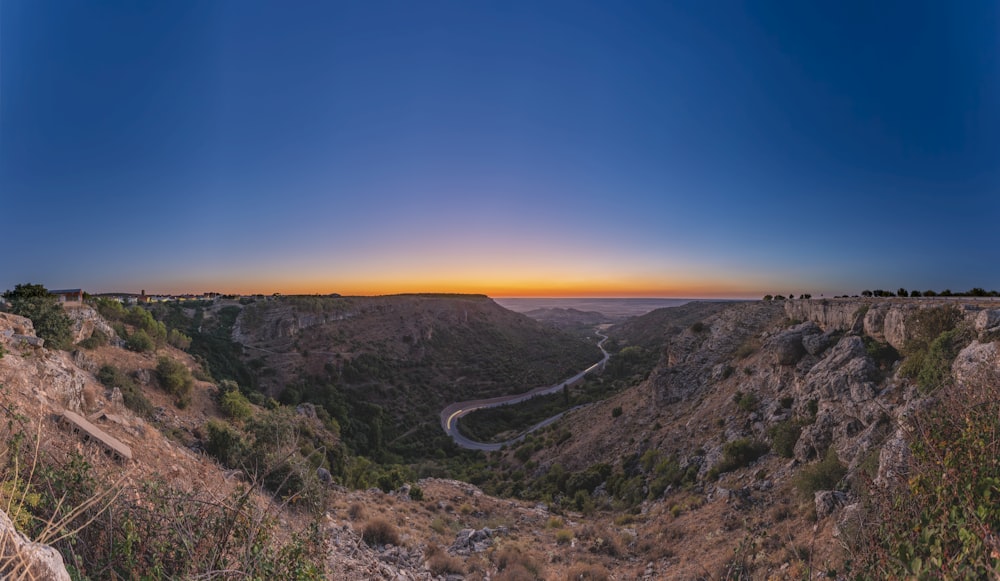 the sun is setting over a canyon in the mountains