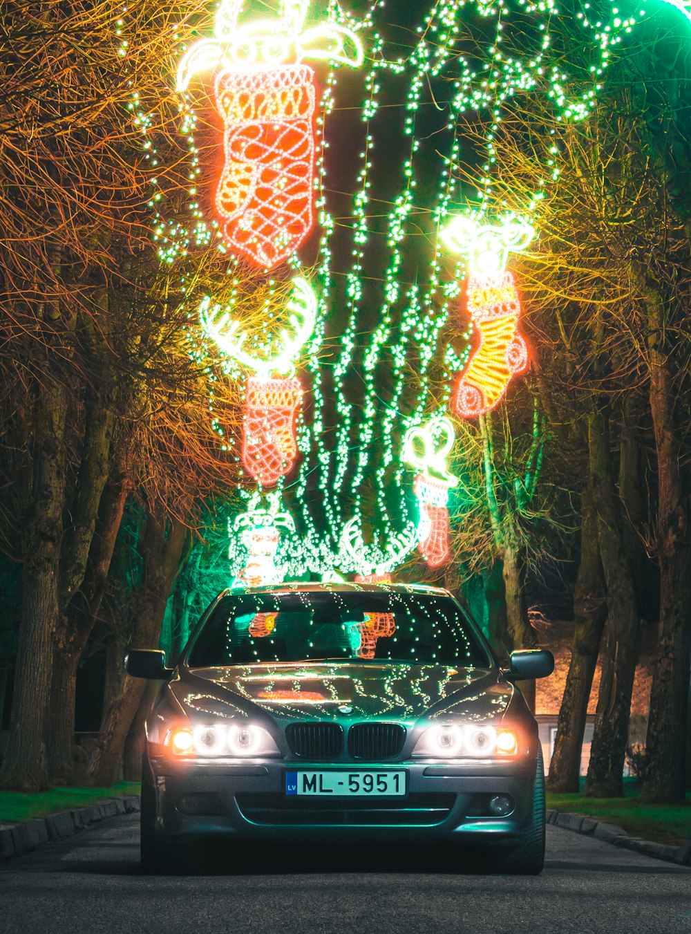 a car driving down a street covered in christmas lights