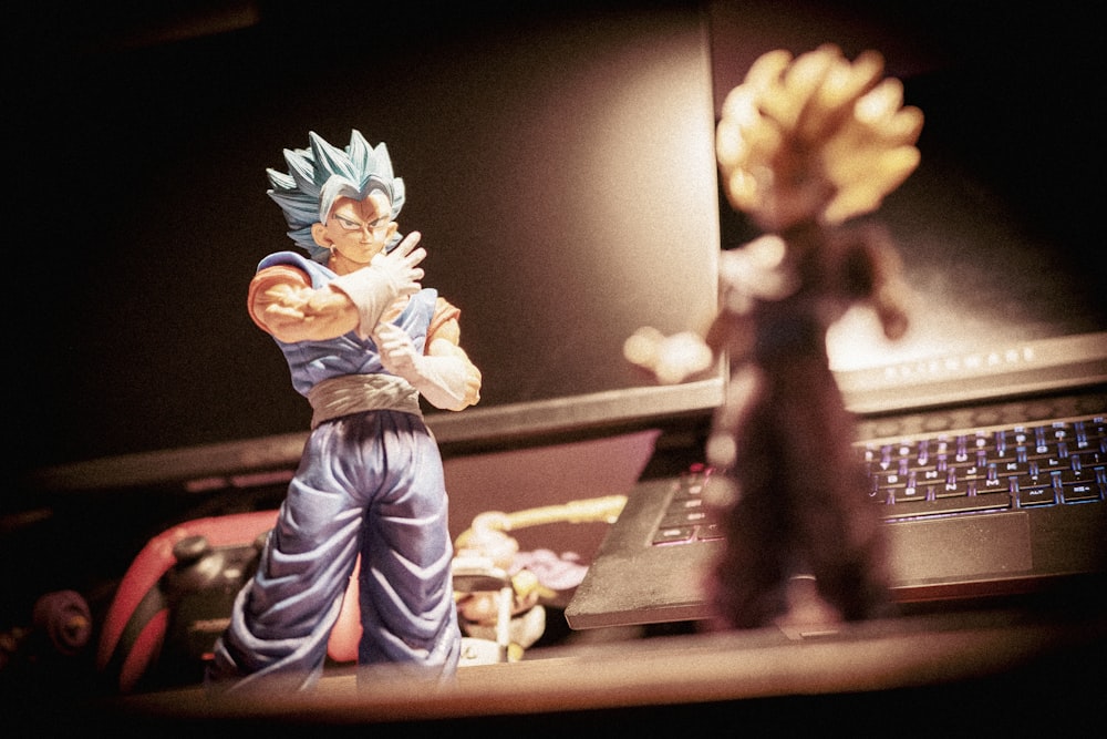 Uma estatueta de Gohan e um laptop em uma mesa