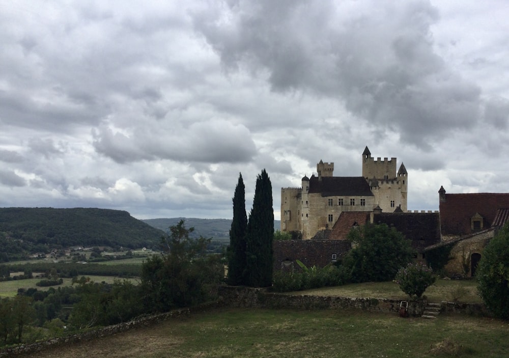 Un grande castello con un sacco di alberi di fronte ad esso