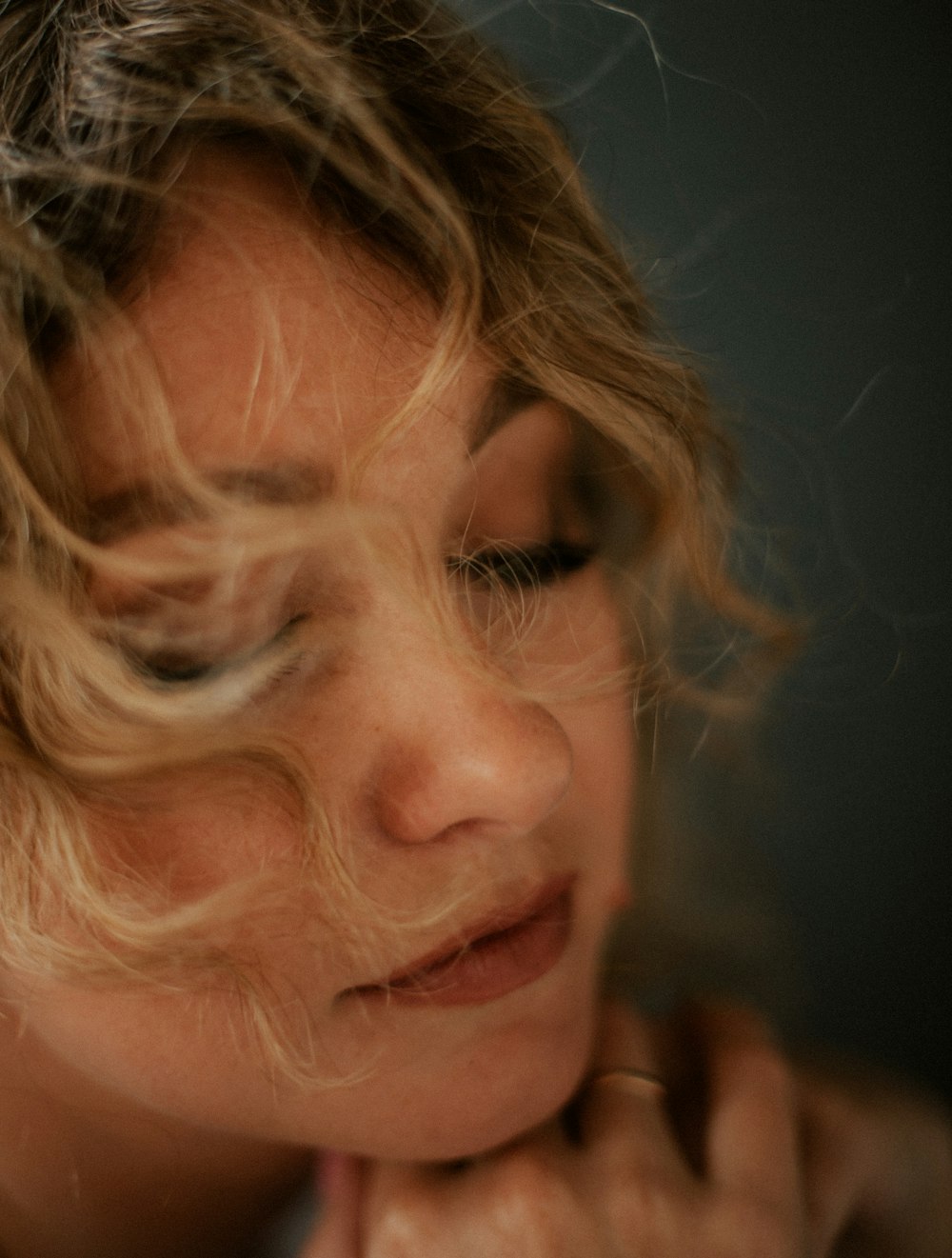 a close up of a woman with her hair blowing in the wind