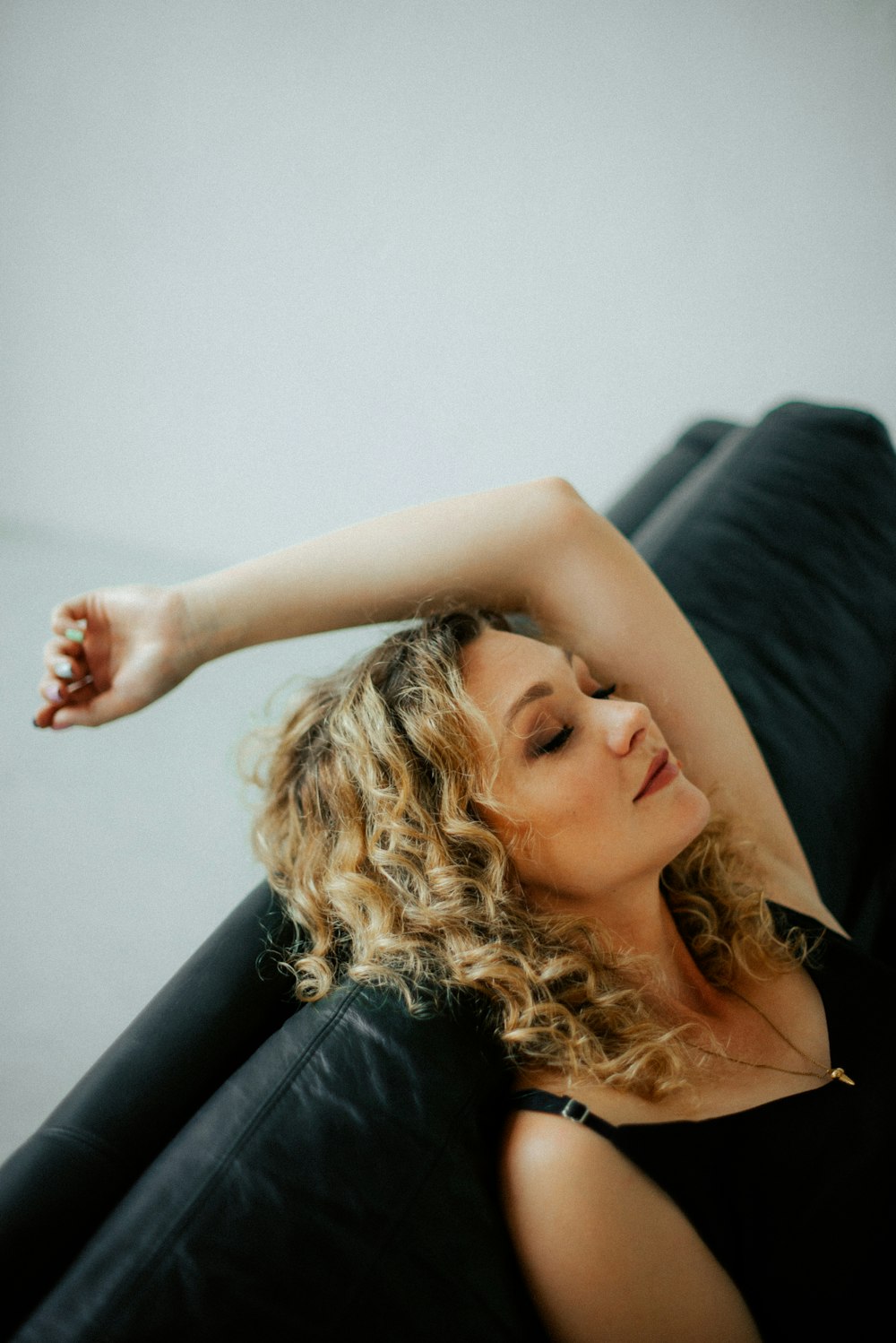 a woman in a black dress sitting on a black chair