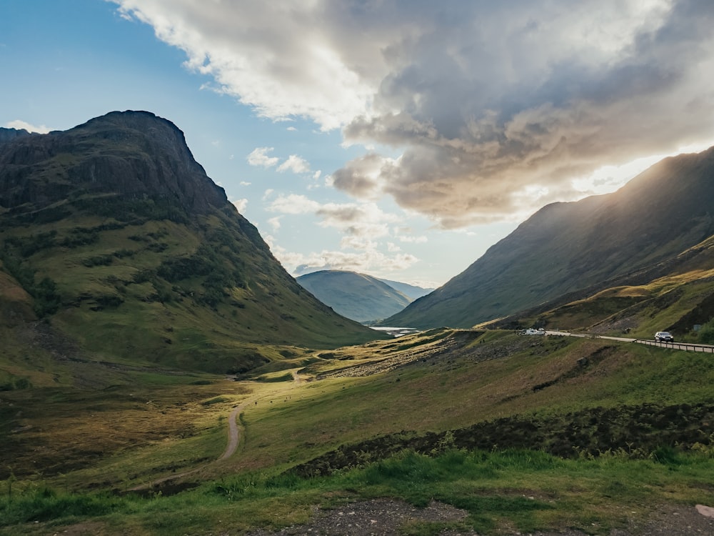 a scenic view of a valley with mountains in the background