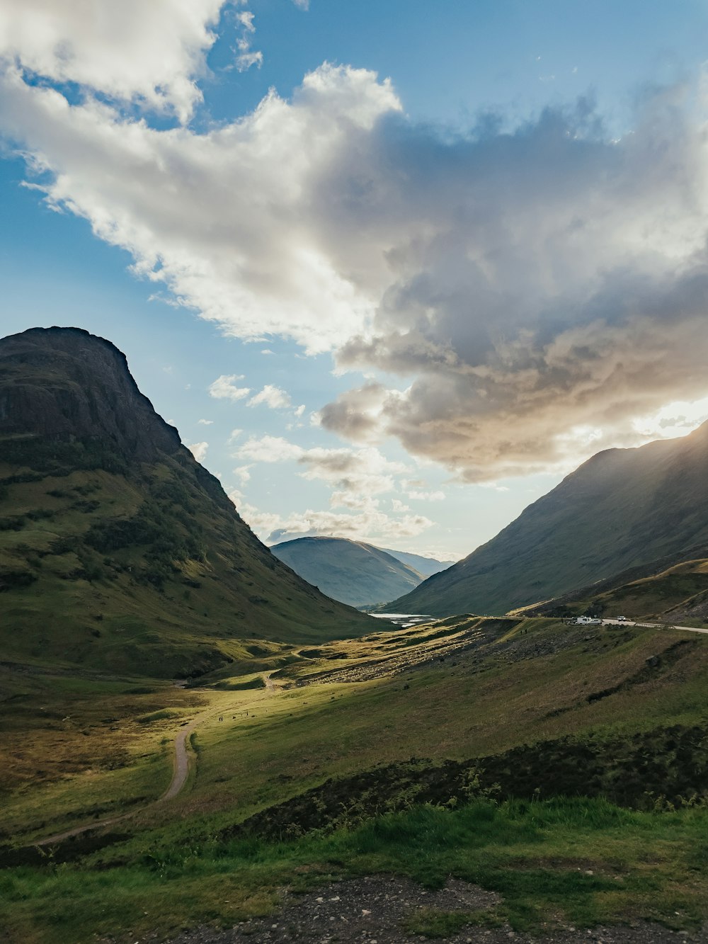 a scenic view of a valley with mountains in the background