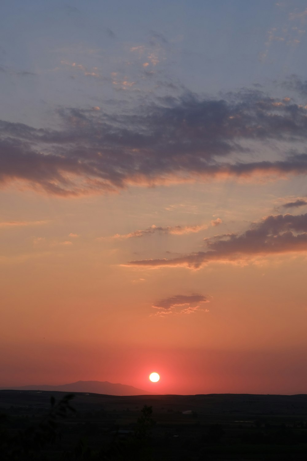 the sun is setting over the horizon of a field