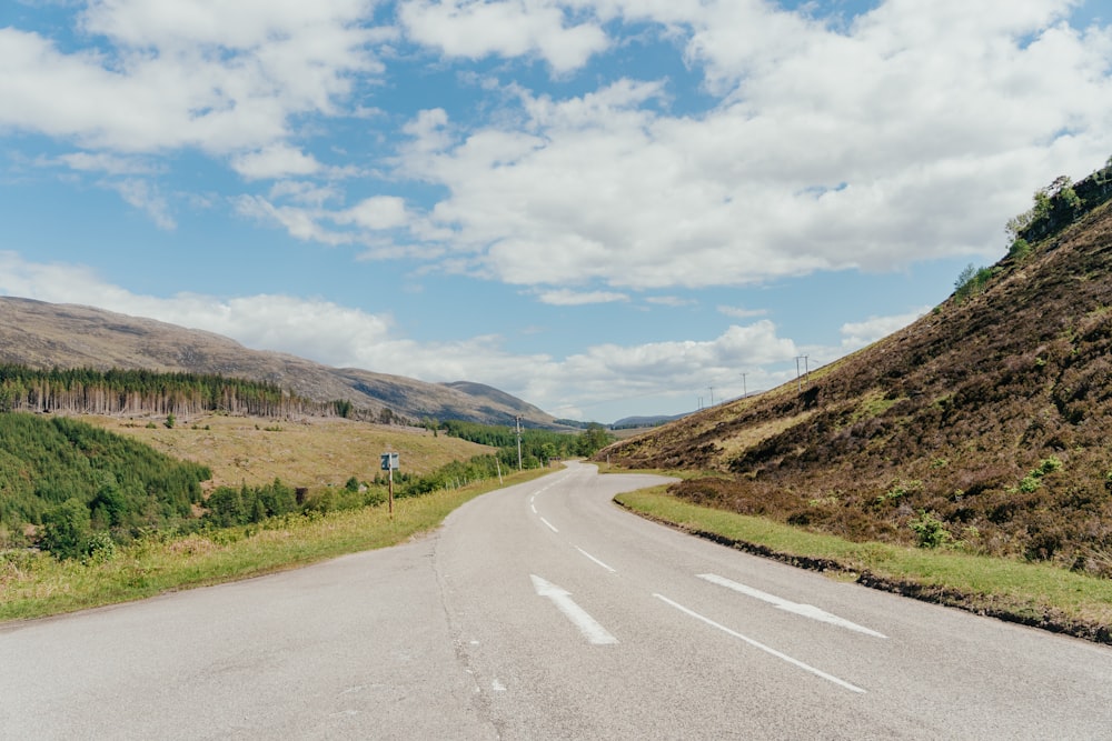 an empty road in the middle of the mountains