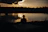 A peaceful outdoor setting with a person sitting quietly, reflecting during sunset.