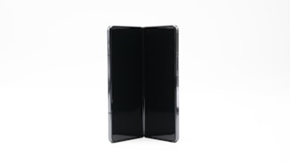 A modern foldable smartphone with a sleek design is open, showing its dual screen capabilities. The device appears to be in a vertical orientation against a plain, light background.