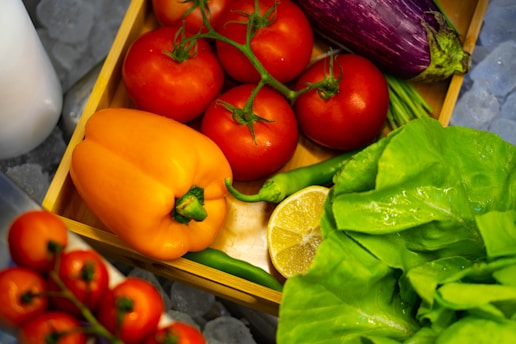 Colorful assortment of fresh fruits and vegetables stacked in wooden crates at a wholesale warehouse