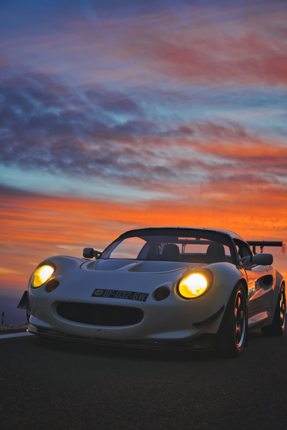 a white sports car parked on the side of the road