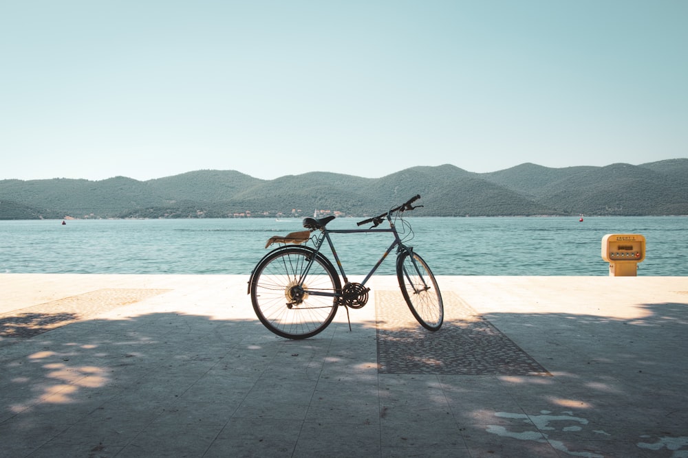 a bike parked on the side of a road next to a body of water