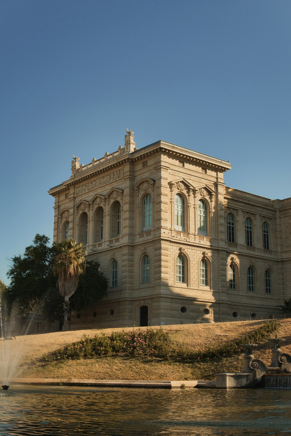 Un gran edificio con una fuente frente a él