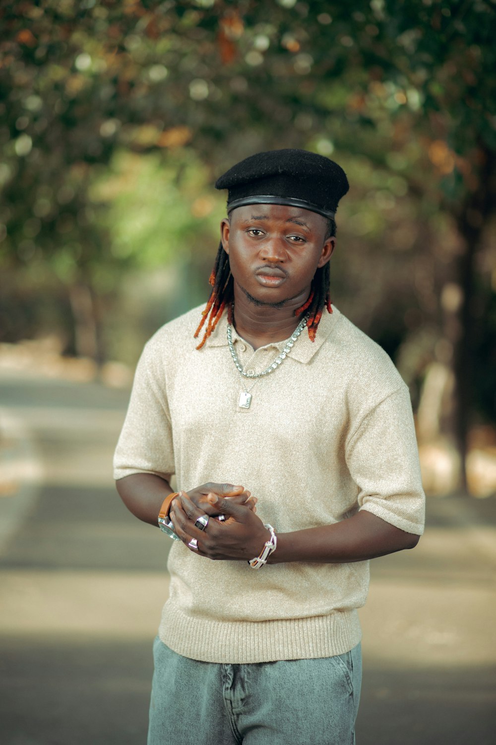 a man with dreadlocks standing on a street