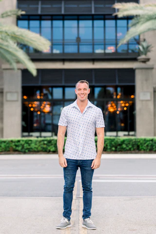 Portrait of Melinda Garrett standing confidently in front of a modern office building in Sarasota.