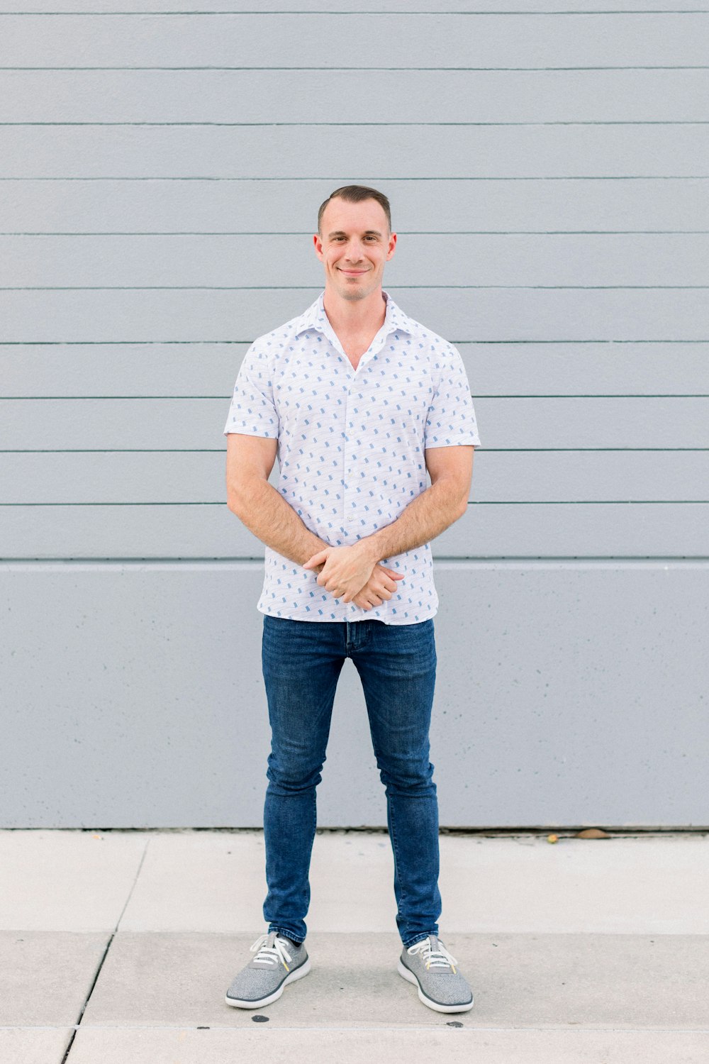 a man standing in front of a gray wall