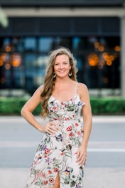 A vibrant, sunlit scene showcasing a smiling young woman wearing a chic maxi dress, standing confidently in an urban setting.