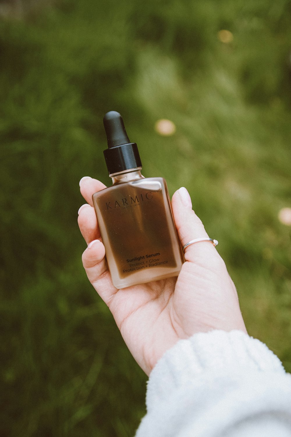 a person holding a bottle of perfume in their hand