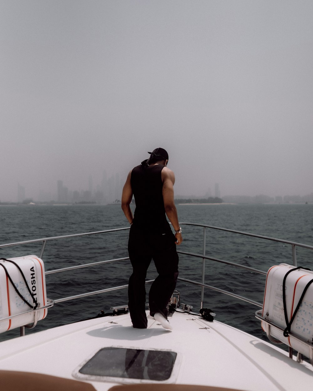 a man standing on the back of a boat in the ocean