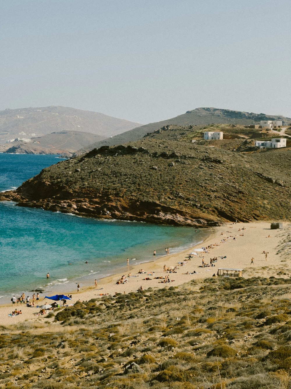 a group of people walking along a beach next to the ocean