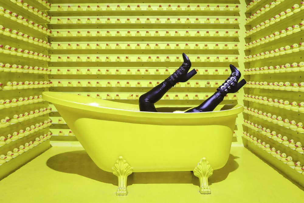 a yellow bathtub with a pair of legs in it