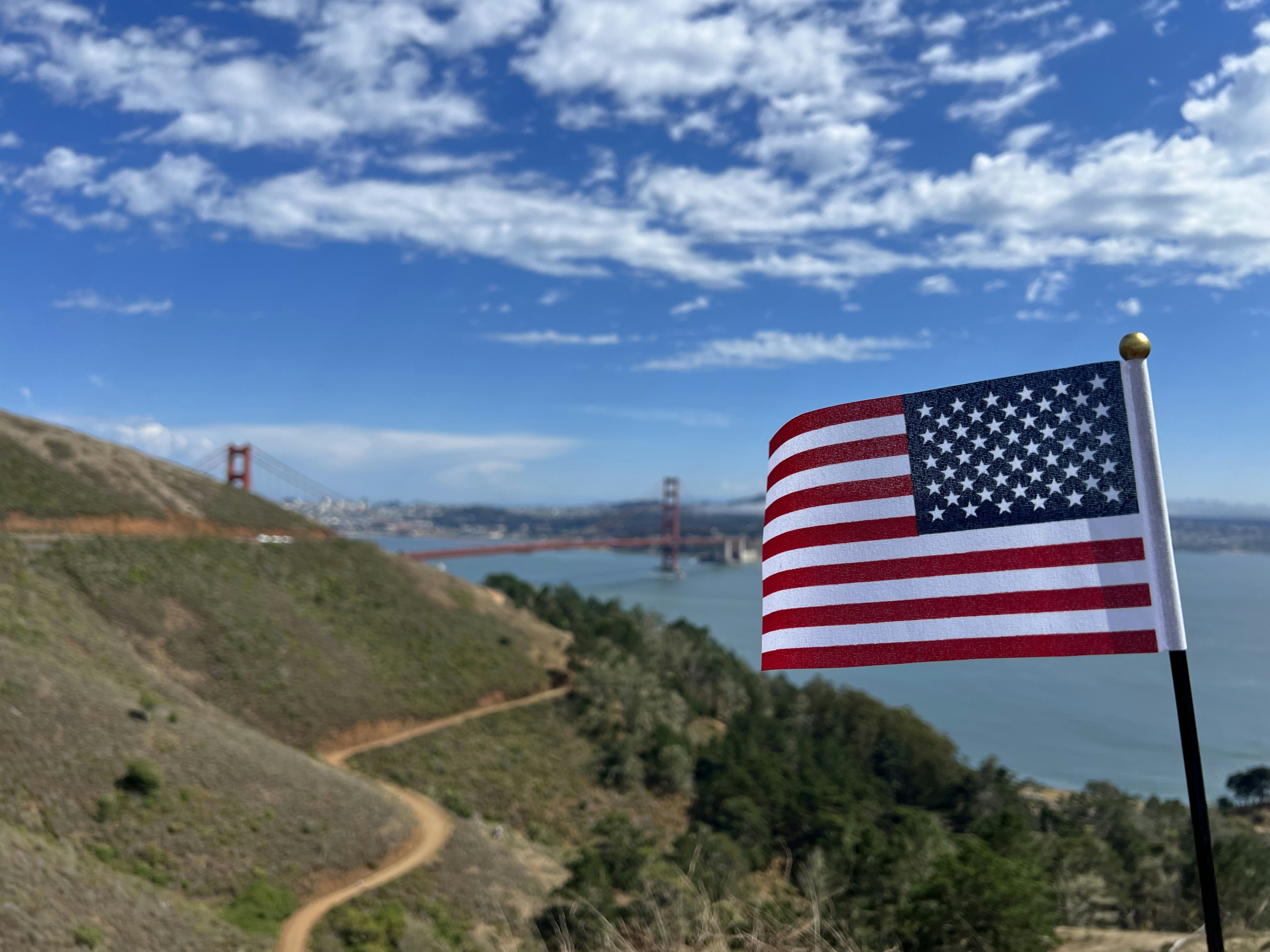 Uma bandeira americana no topo de uma colina com vista para a ponte Golden Gate