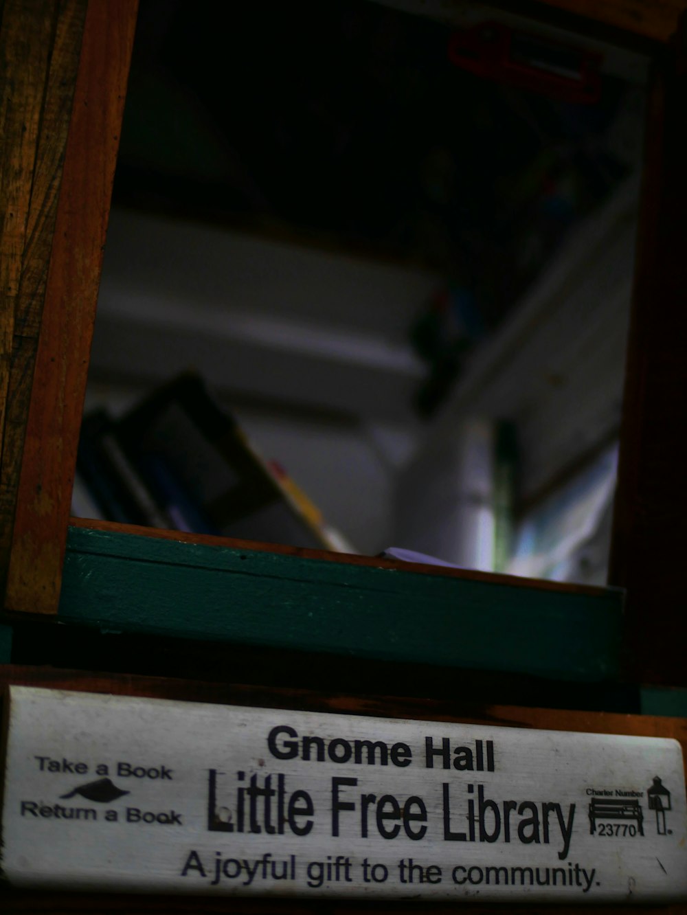 a little free library sign in front of a mirror