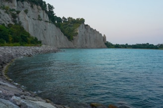 A serene Mediterranean coastline with sunlit cliffs and clear blue waters, evoking natural purity and timeless beauty.