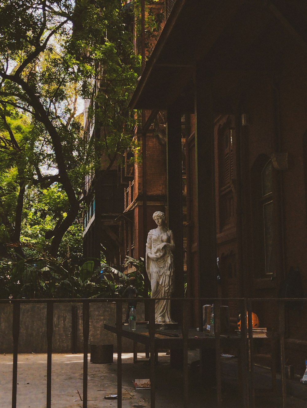 a statue of a woman standing in front of a building