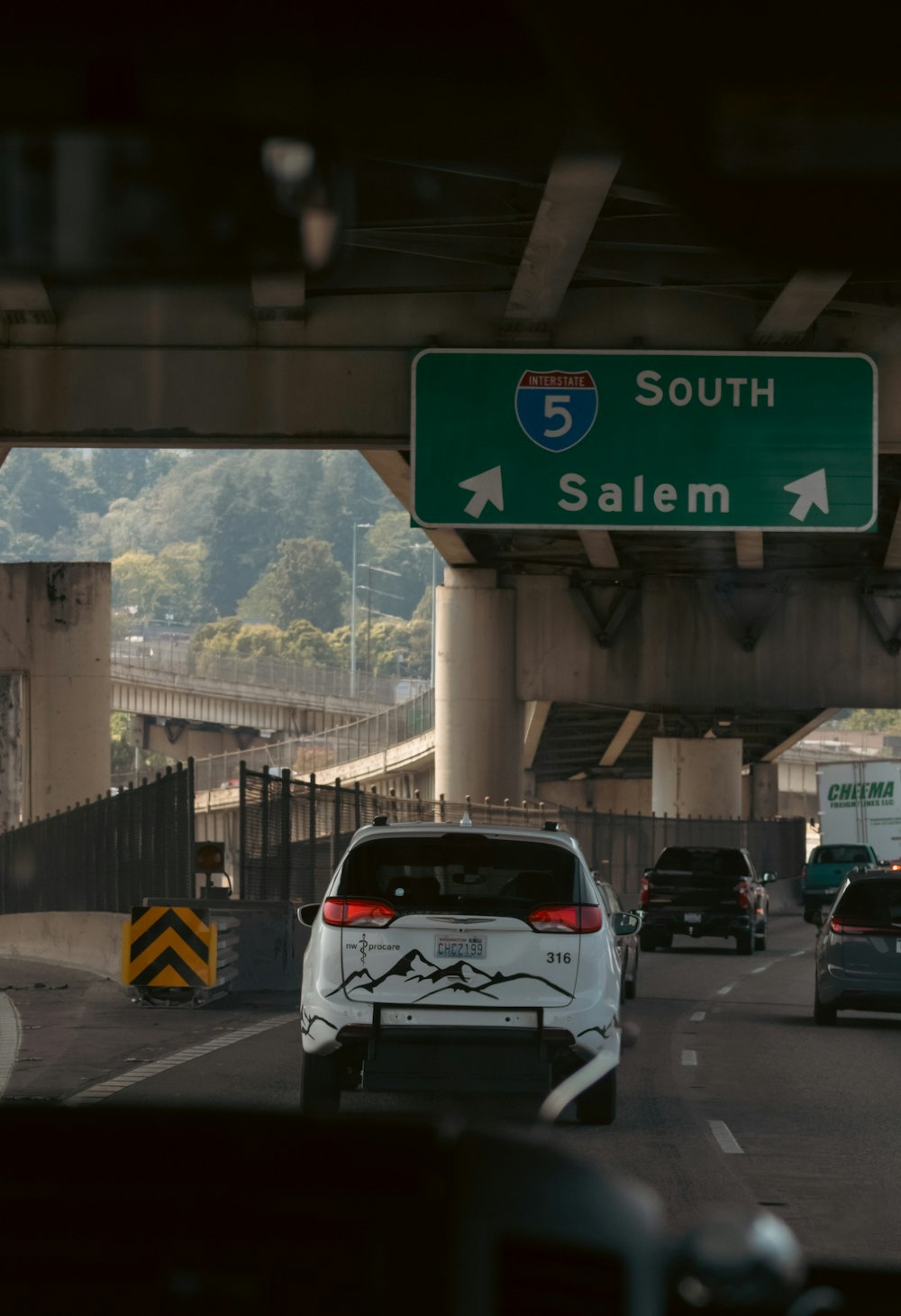 a car driving down a highway under a bridge