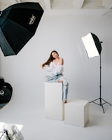 a woman sitting on top of a white box