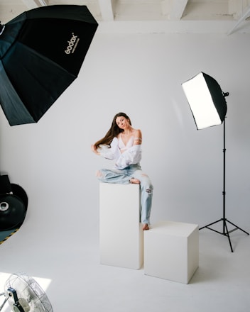 a woman sitting on top of a white box