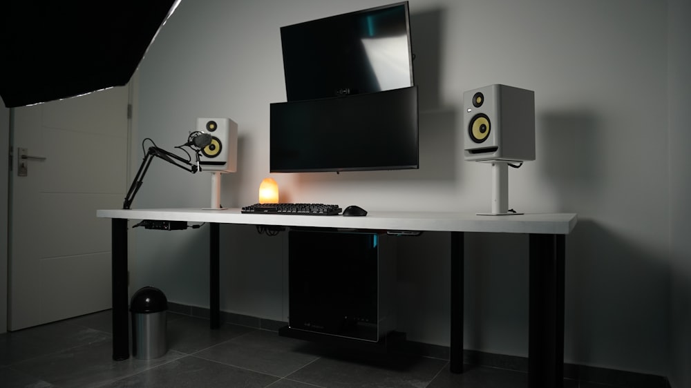 a desk with speakers and a monitor on it