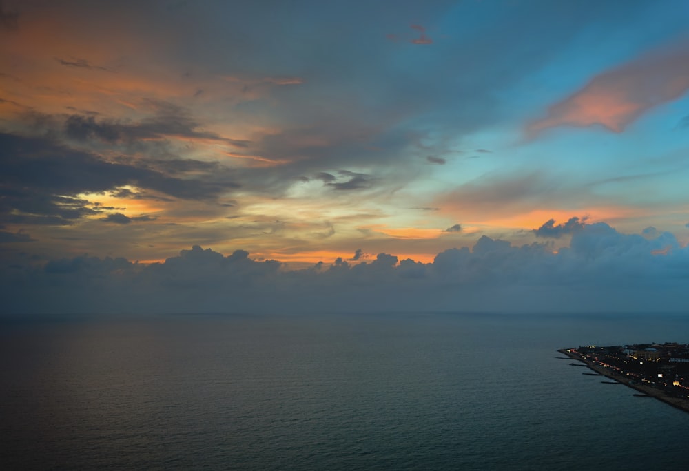 a view of the ocean at sunset from a high point of view