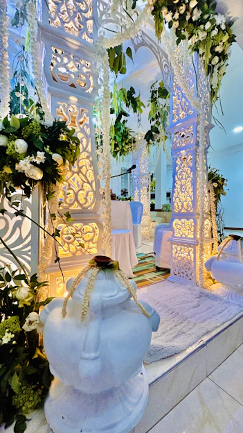 A beautifully decorated wedding venue with elegant cream and gold accents, softly lit for a romantic evening.