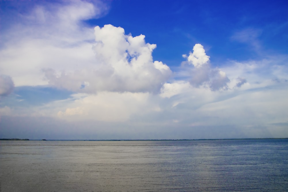 a large body of water under a cloudy blue sky