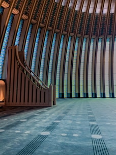 a large room with a spiral staircase and stained glass windows