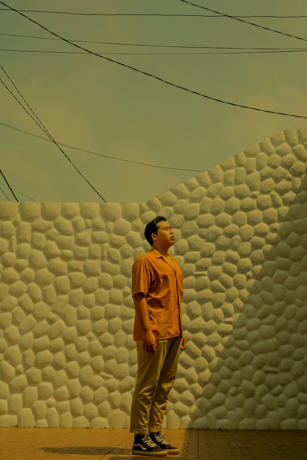 a man standing in front of a white wall