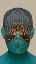 A digitally rendered face exhibiting a metallic and abstract texture, with distorted and mirrored features. The surface is smooth and reflective, suggesting a futuristic or alien design. Colors are rich and vibrant, with a mix of blue, gold, and hints of red. The image conveys an otherworldly and surreal appearance due to the unique texture and symmetry.