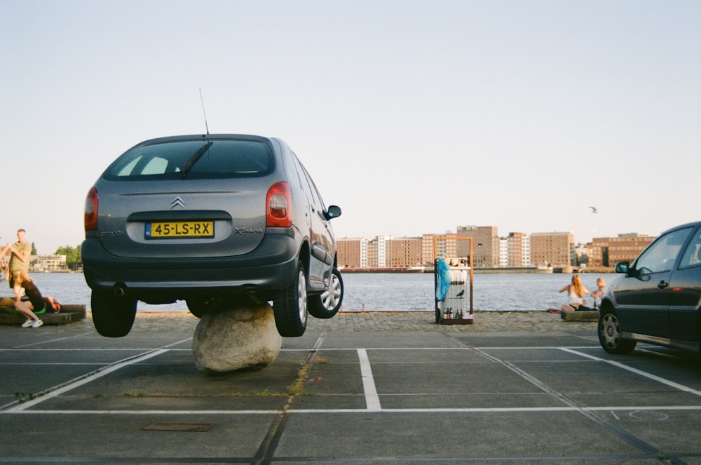 a car parked in a parking lot next to a body of water