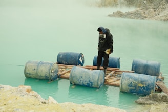 a man standing on a raft in a body of water
