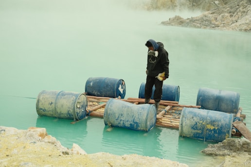 a man standing on a raft in a body of water